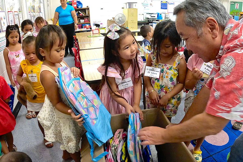 students receiving backpacks
